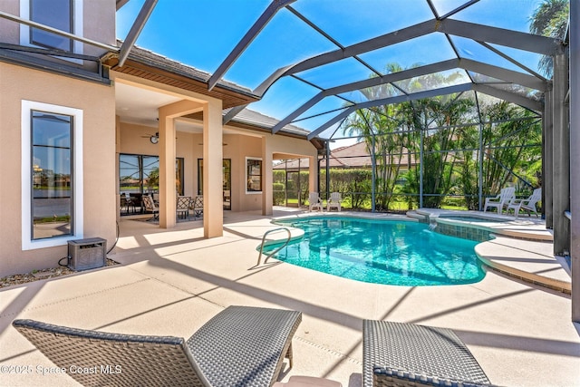 view of pool featuring a patio area, a pool with connected hot tub, and a lanai