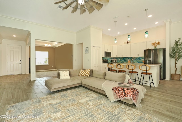 4710 Hebron Dr, Merritt Island, FL 32953 - living area with ceiling fan with notable chandelier, wood tiled floor, and crown molding