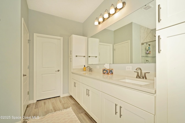 4710 Hebron Dr, Merritt Island, FL 32953 - full bathroom featuring a stall shower, wood finished floors, a sink, and visible vents