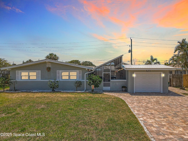 125 Terry St, Indian Harbour Beach, FL 32937 - mid-century home with fence, a front lawn, stucco siding, decorative driveway, and a garage