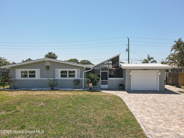 125 Terry St, Indian Harbour Beach, FL 32937 - mid-century inspired home featuring decorative driveway, an attached garage, fence, a front yard, and stucco siding