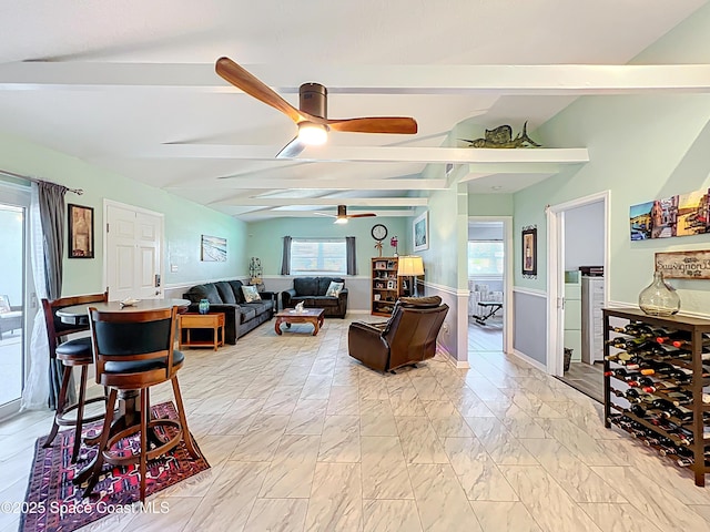 125 Terry St, Indian Harbour Beach, FL 32937 - living area featuring marble finish floor, a ceiling fan, lofted ceiling with beams, and a wainscoted wall