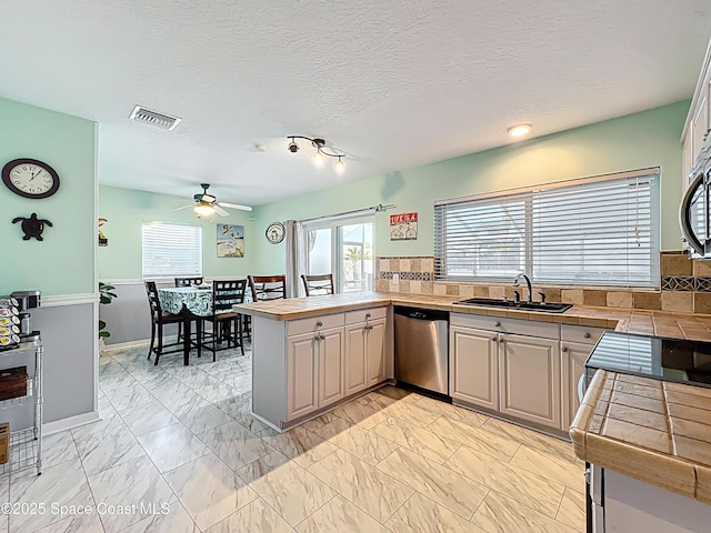 125 Terry St, Indian Harbour Beach, FL 32937 - kitchen with a peninsula, a sink, visible vents, a ceiling fan, and appliances with stainless steel finishes