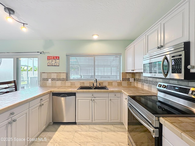125 Terry St, Indian Harbour Beach, FL 32937 - kitchen featuring white cabinets, marble finish floor, stainless steel appliances, a sink, and tasteful backsplash