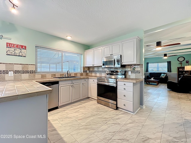 125 Terry St, Indian Harbour Beach, FL 32937 - kitchen featuring stainless steel appliances, marble finish floor, a sink, and backsplash