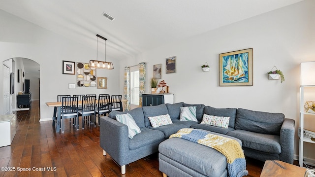 1546 Litchfield Dr, Melbourne, FL 32904 - living room featuring dark wood-style flooring, baseboards, visible vents, lofted ceiling, and arched walkways