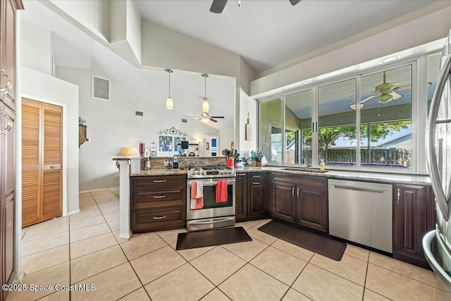 kitchen featuring light tile patterned floors, appliances with stainless steel finishes, a peninsula, and a ceiling fan