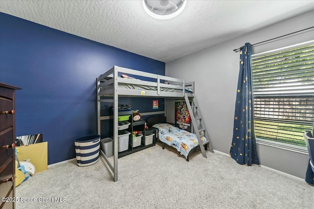 carpeted bedroom with baseboards and a textured ceiling