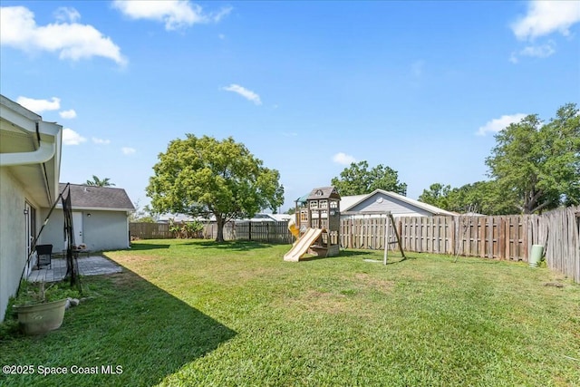 view of yard with a patio area, a fenced backyard, and a playground