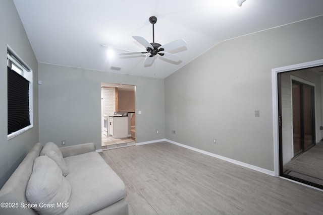881 Brookson Ave NW, Palm Bay, FL 32907 - unfurnished living room with light wood-type flooring, baseboards, visible vents, lofted ceiling, and a ceiling fan