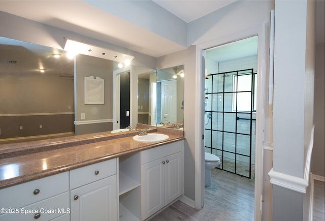 881 Brookson Ave NW, Palm Bay, FL 32907 - bathroom with baseboards, wood finished floors, toilet, and vanity