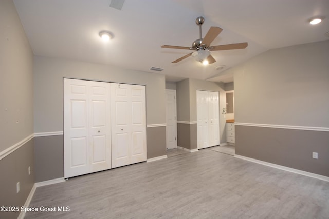 881 Brookson Ave NW, Palm Bay, FL 32907 - unfurnished bedroom featuring wood finished floors, two closets, baseboards, lofted ceiling, and visible vents