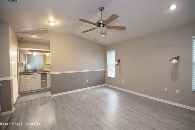 881 Brookson Ave NW, Palm Bay, FL 32907 - unfurnished living room with vaulted ceiling, visible vents, baseboards, light wood-style flooring, and ceiling fan