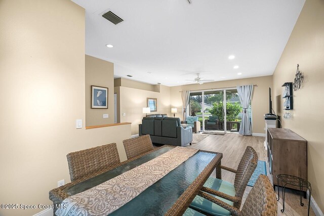 dining room featuring wood finished floors, baseboards, a ceiling fan, and visible vents