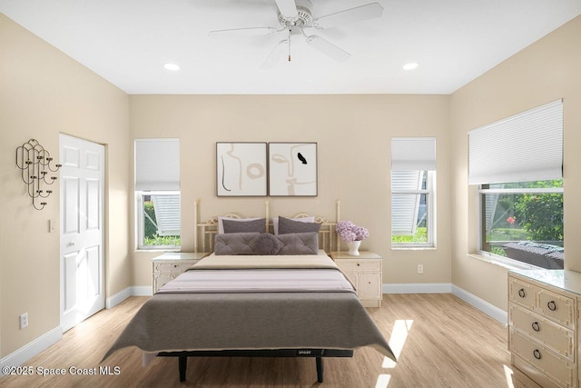 bedroom featuring light wood-style flooring, multiple windows, and baseboards