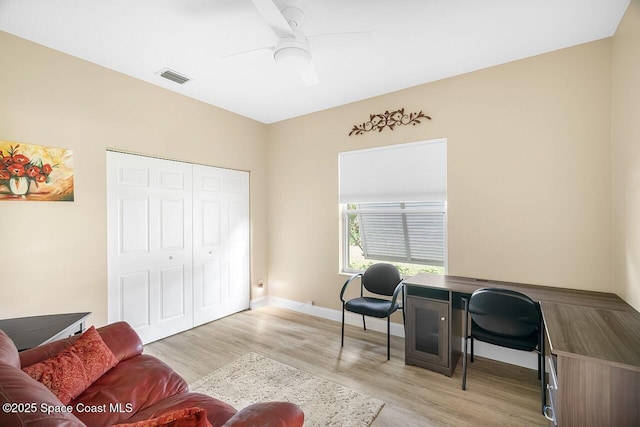 office featuring light wood finished floors, visible vents, baseboards, and ceiling fan