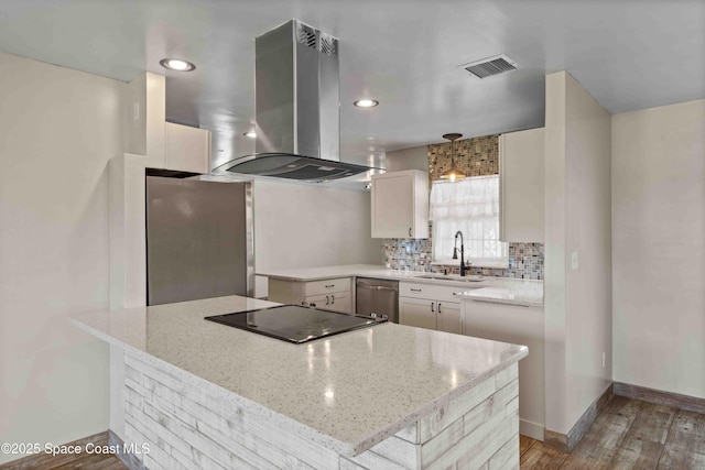 kitchen with tasteful backsplash, visible vents, appliances with stainless steel finishes, island exhaust hood, and a sink