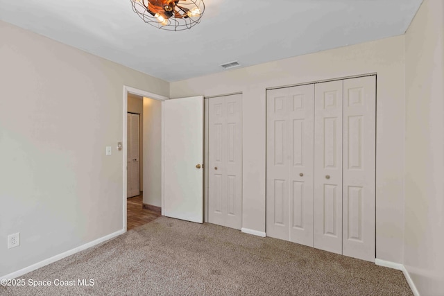 unfurnished bedroom with visible vents, baseboards, two closets, and carpet floors