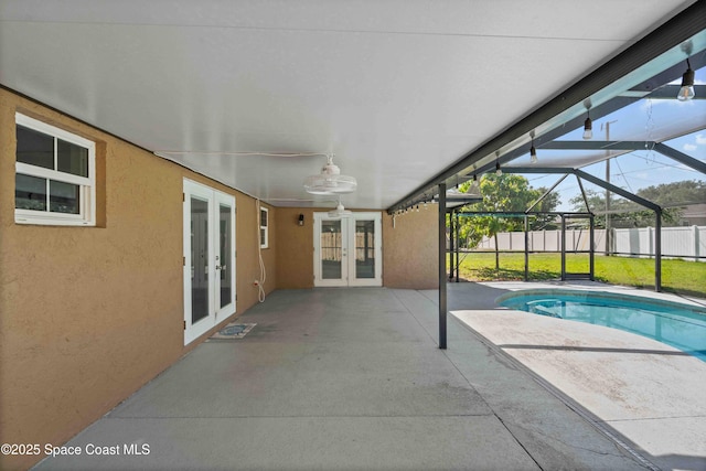 view of pool featuring ceiling fan, glass enclosure, a patio area, fence, and french doors