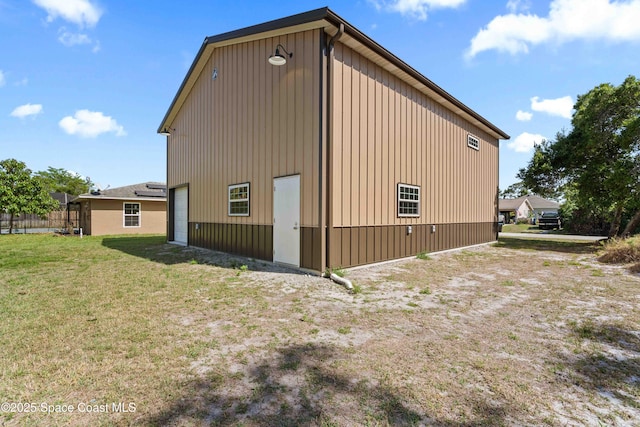 view of side of home with an outbuilding, a garage, and a lawn