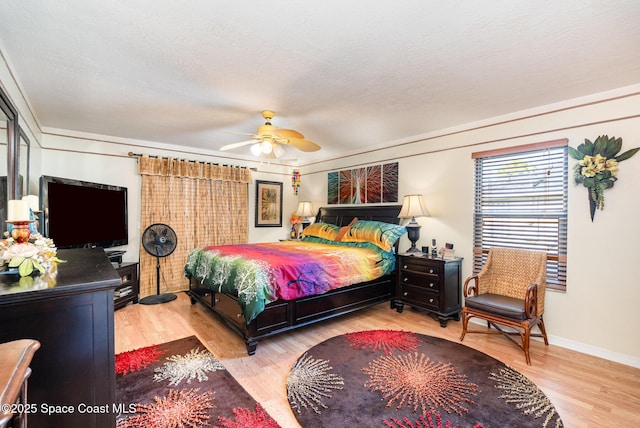 bedroom with baseboards, ceiling fan, and wood finished floors