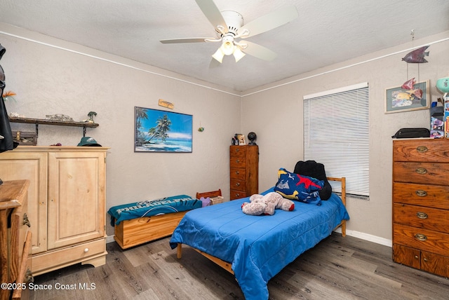 bedroom featuring baseboards, a ceiling fan, and wood finished floors