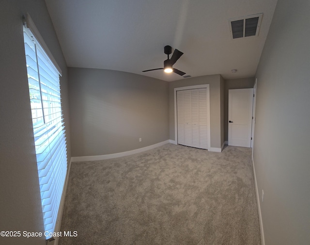 unfurnished bedroom with a closet, baseboards, carpet, and visible vents