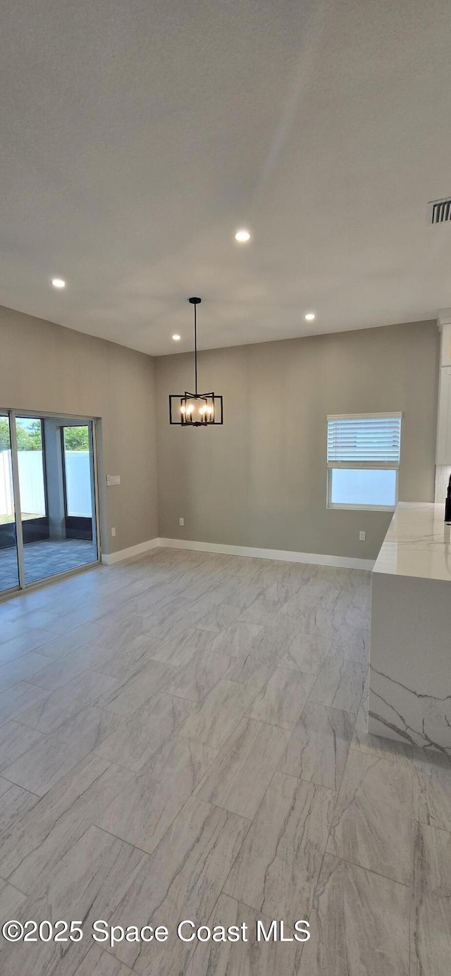 unfurnished living room featuring recessed lighting, marble finish floor, and a healthy amount of sunlight