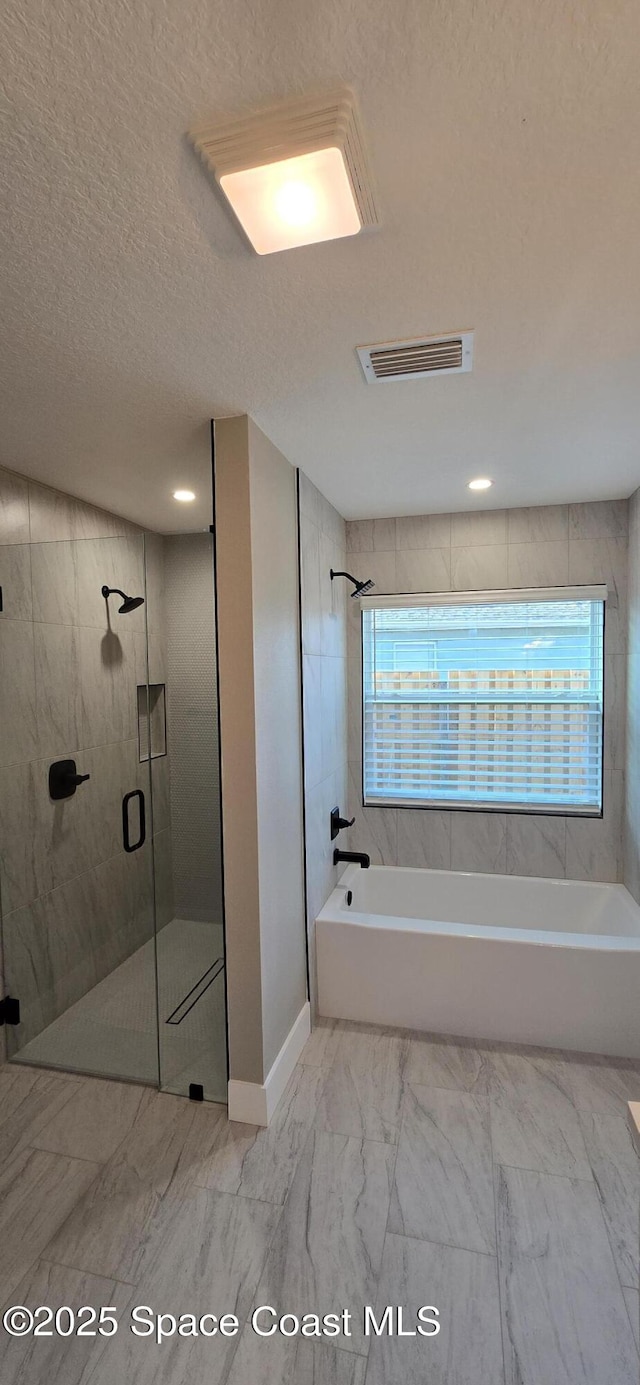 full bathroom featuring visible vents, baseboards, marble finish floor, and a textured ceiling