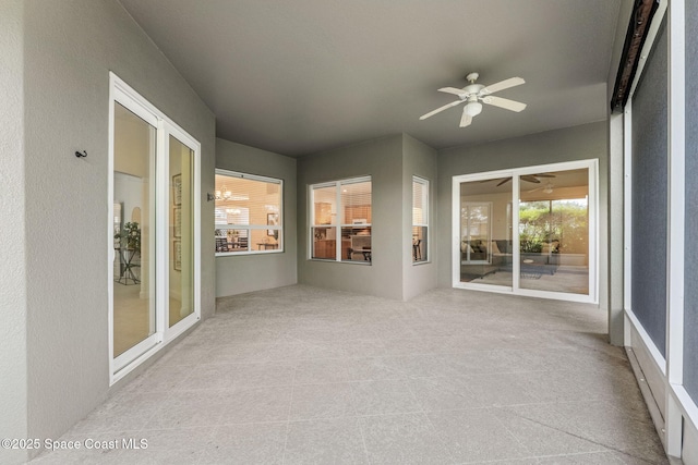 unfurnished sunroom featuring ceiling fan