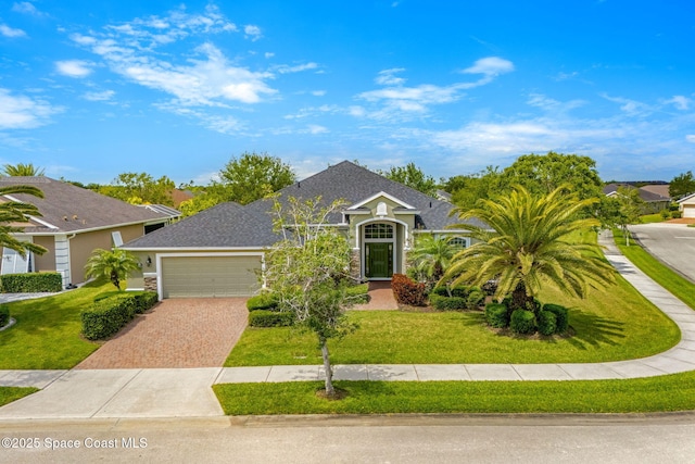 view of front of home with stone siding, driveway, a front yard, and a garage