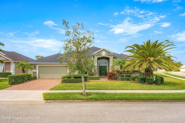 view of front of home featuring stone siding, an attached garage, a front yard, stucco siding, and decorative driveway