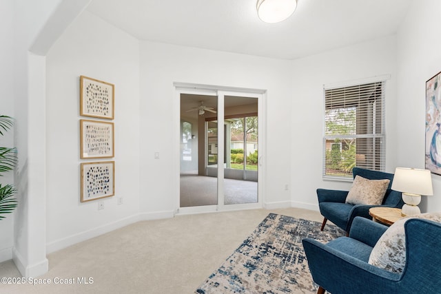 sitting room with carpet floors, a ceiling fan, and baseboards
