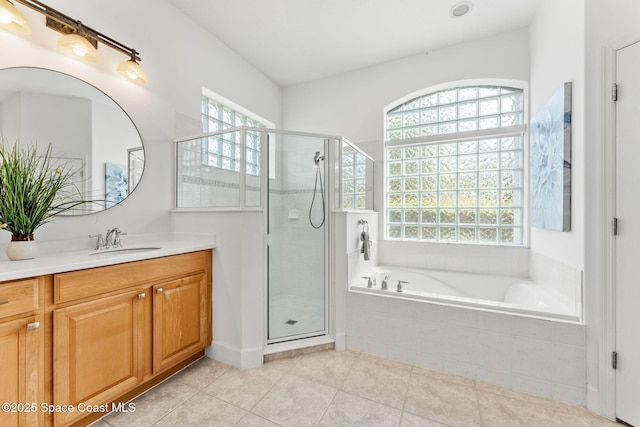 full bathroom featuring a shower stall, a bath, a wealth of natural light, and vanity