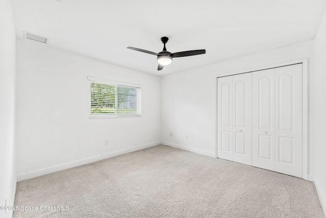unfurnished bedroom featuring carpet, a closet, baseboards, and visible vents