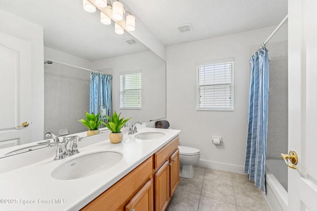bathroom featuring toilet, tile patterned floors, a sink, and visible vents