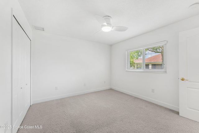unfurnished bedroom featuring baseboards, a ceiling fan, carpet floors, and a closet