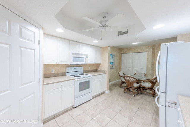 8941 Lake Dr Unit 204, Cape Canaveral, FL 32920 - kitchen with visible vents, white cabinets, light countertops, white appliances, and a tray ceiling
