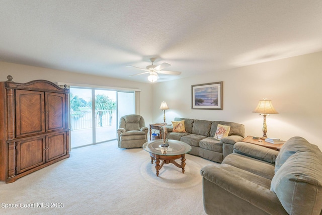 8941 Lake Dr Unit 204, Cape Canaveral, FL 32920 - living area featuring light colored carpet, a textured ceiling, and ceiling fan
