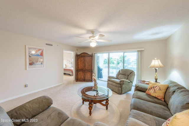 8941 Lake Dr Unit 204, Cape Canaveral, FL 32920 - living room featuring a textured ceiling, light colored carpet, a ceiling fan, and visible vents