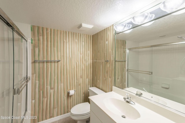 8941 Lake Dr Unit 204, Cape Canaveral, FL 32920 - full bathroom featuring visible vents, toilet, a textured ceiling, vanity, and a shower with shower door