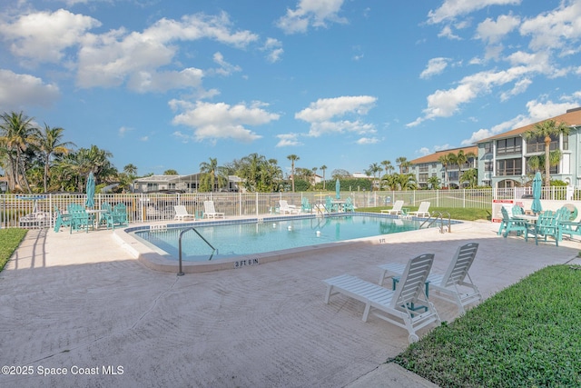 community pool with fence and a patio area