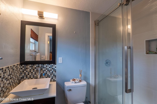 bathroom with toilet, a textured ceiling, vanity, backsplash, and a stall shower