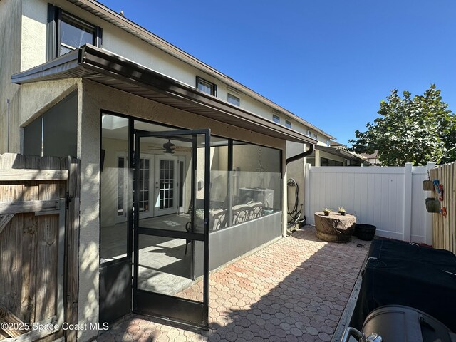 view of patio / terrace featuring fence and a sunroom