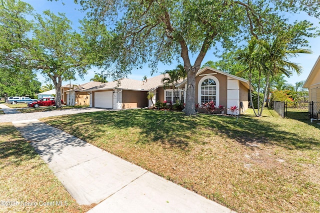 single story home featuring a garage, fence, concrete driveway, a front lawn, and stucco siding