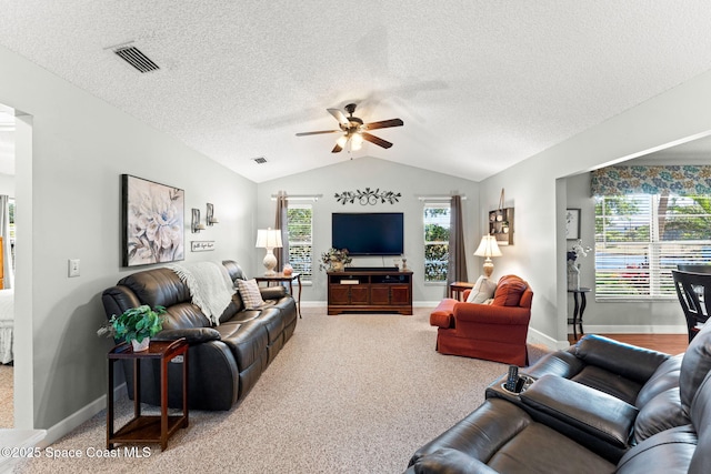 living area featuring a textured ceiling, a ceiling fan, visible vents, carpet flooring, and lofted ceiling