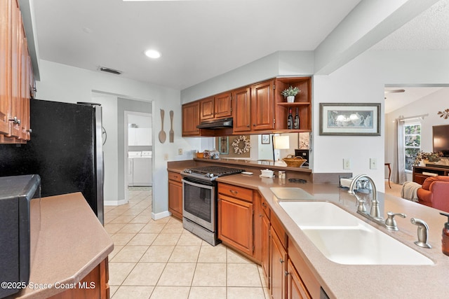 kitchen with under cabinet range hood, visible vents, brown cabinetry, appliances with stainless steel finishes, and a sink