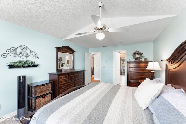 bedroom featuring visible vents, baseboards, a ceiling fan, and a textured ceiling