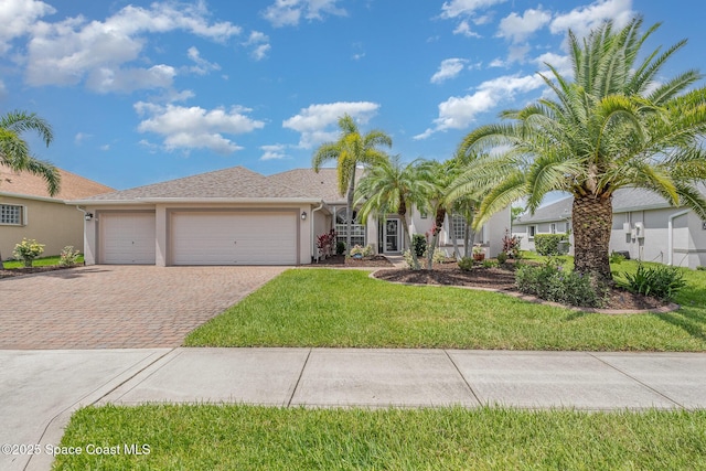 3156 Quint Dr, Melbourne, FL 32940 - view of front of home featuring decorative driveway, stucco siding, an attached garage, and a front lawn