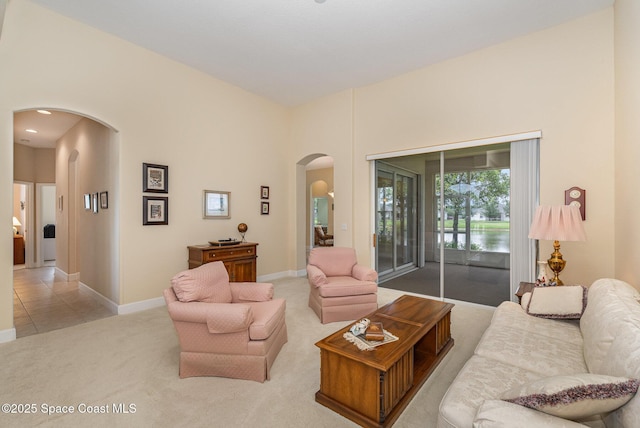 3156 Quint Dr, Melbourne, FL 32940 - living room featuring arched walkways, light carpet, baseboards, and a water view